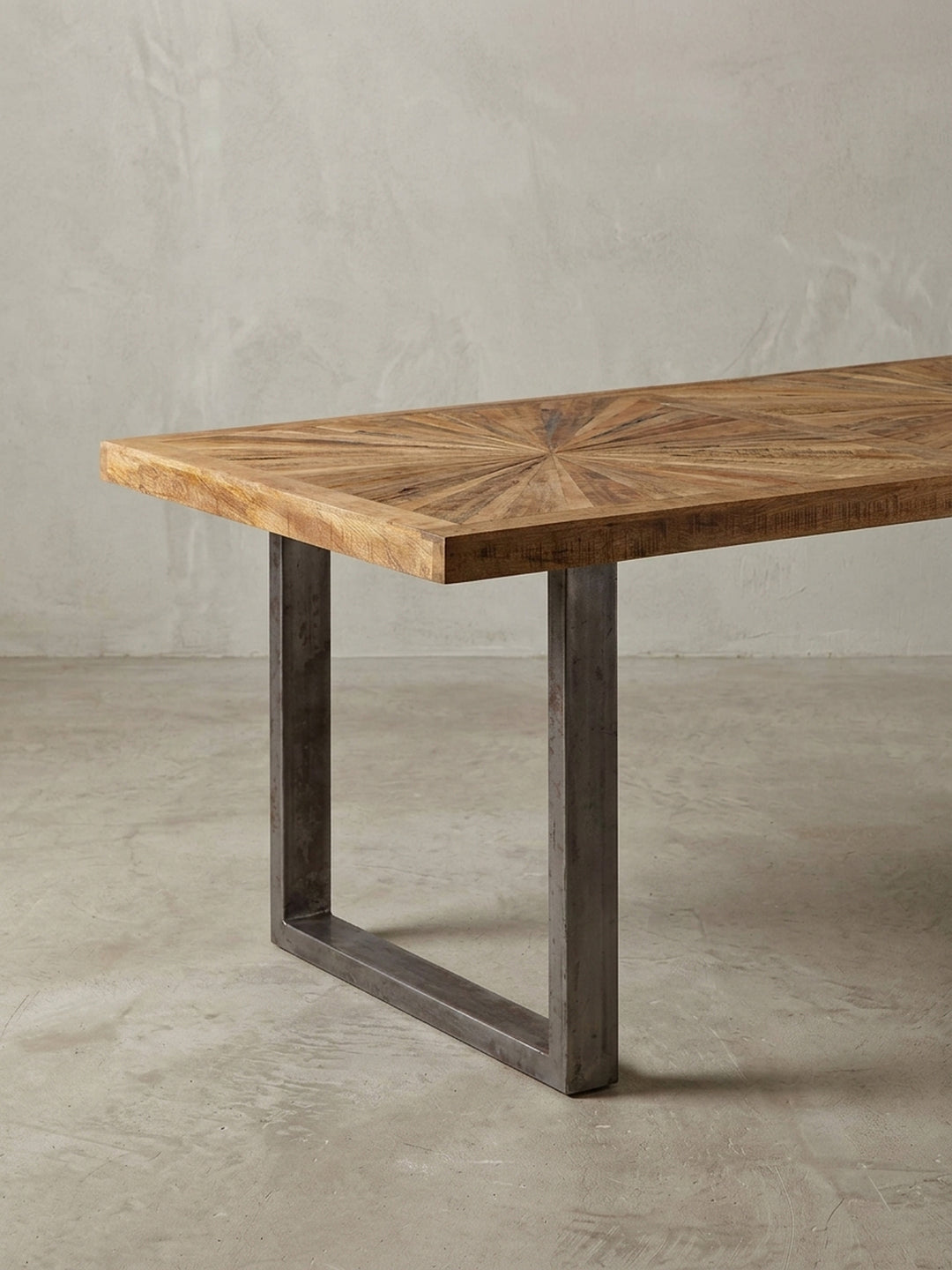Alternative Perspektive des Esstisches, die das spannende Farbspiel des natürlichen Mangoholzes und die industrielle Textur der rustikalen Edelstahl-Beine perfekt einfängt._