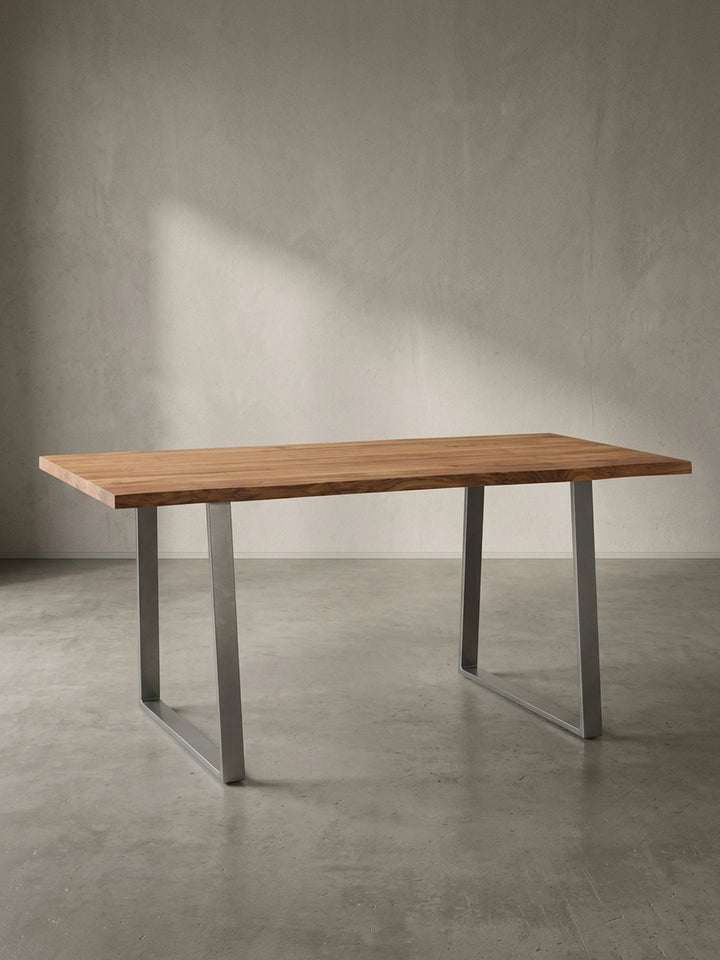 Freigestellter Esstisch 120 cm aus Akazie Massivholz mit Trapezbeinen aus Metall in Chrom, Frontalansicht auf weißem Hintergrund._
