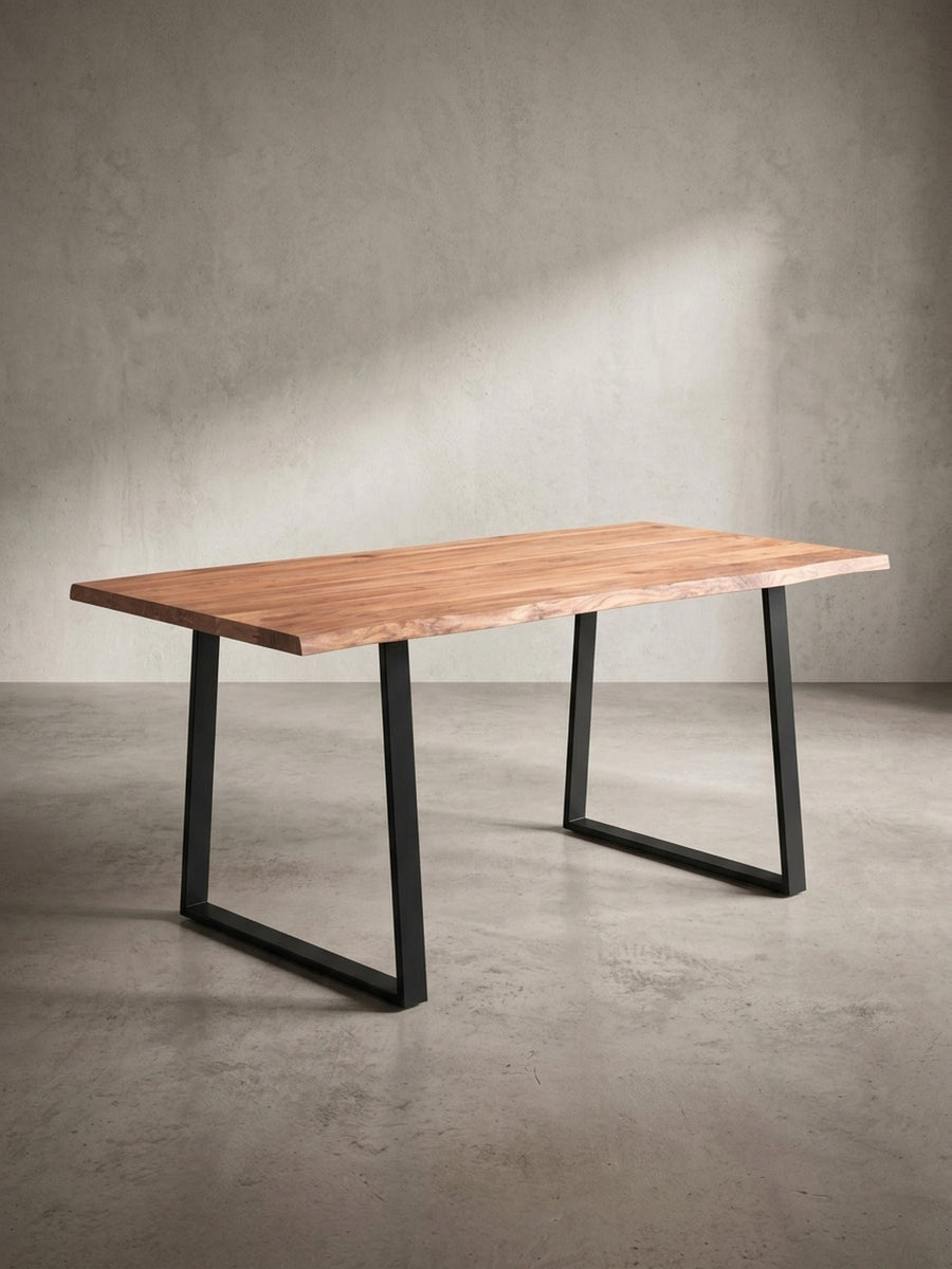 Seitenansicht des Industrial-Esstisches, die die schlanke Silhouette des schwarzen Metallgestells unter der massiven Akazienplatte zeigt._