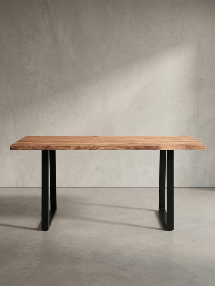 Schräge Ansicht des Küchentisches aus Massivholz, die die Tiefe der 4 cm dicken Tischplatte und das Design der Trapezbeine hervorhebt._