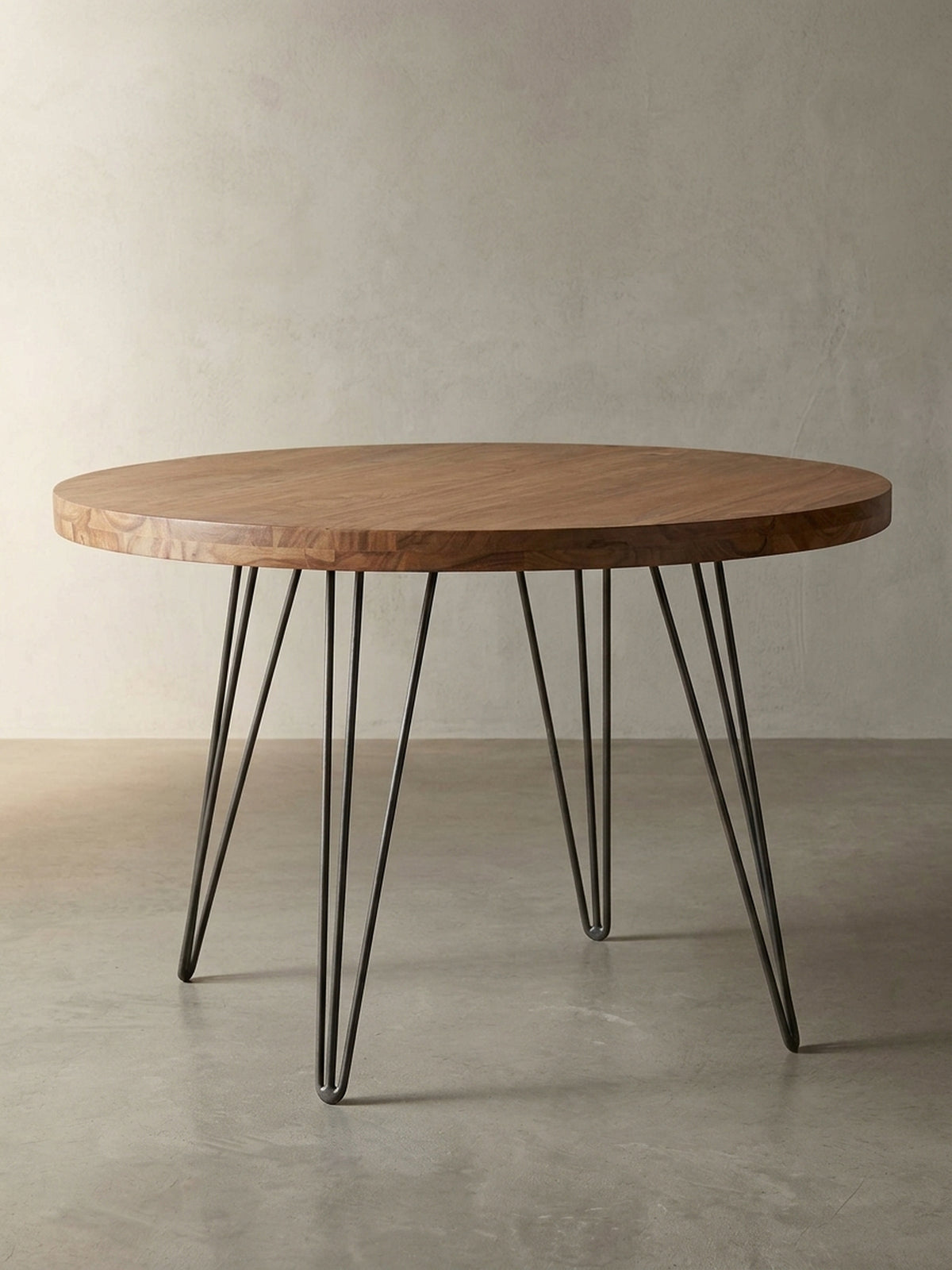 Frontalansicht des runden Design-Esstisches. Der edle Holztisch mit 120 cm Durchmesser kombiniert eine massive Sheesham-Platte mit vier mattschwarzen Metallbeinen im Industrial-Look.