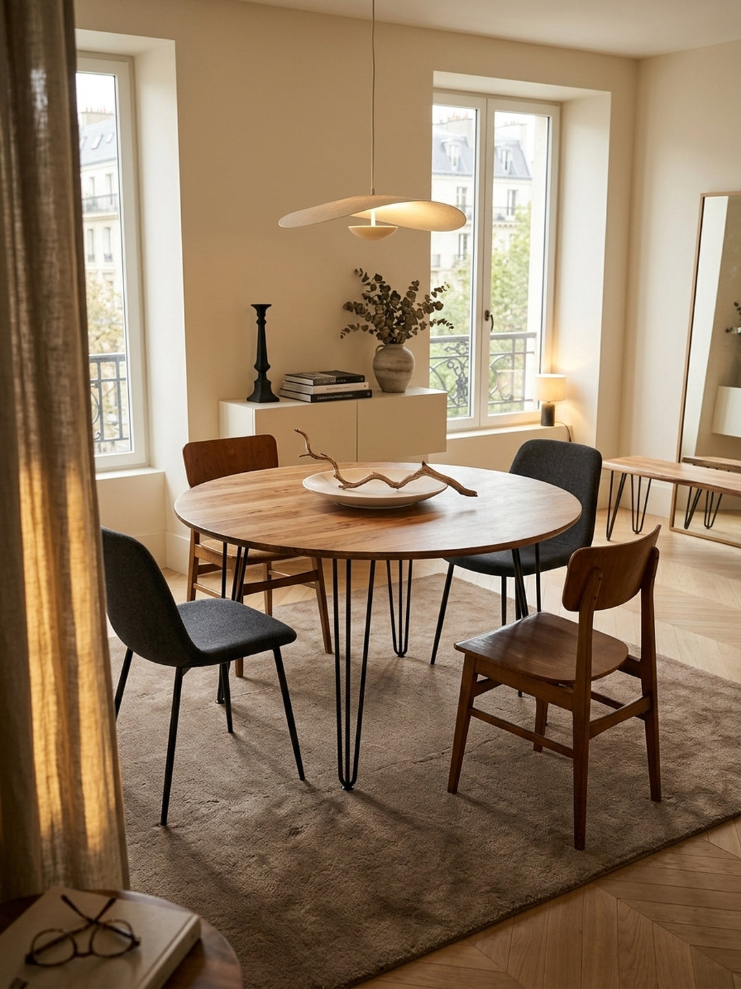 Runder Esstisch aus massivem Sheesham-Holz im stilvollen Esszimmer. Der 120cm Holztisch mit schwarzen Hairpin-Legs steht auf einem hellen Teppich im eleganten, modernen Ambiente._