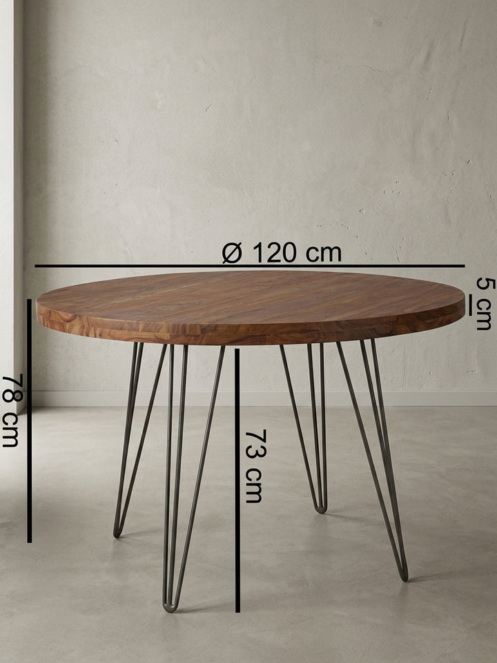 Detailansicht der Unterkonstruktion des runden Holztisches. Die stabile Verschraubung der mattschwarzen Metallfüße an der massiven Sheesham-Tischplatte garantiert einen sicheren Stand._