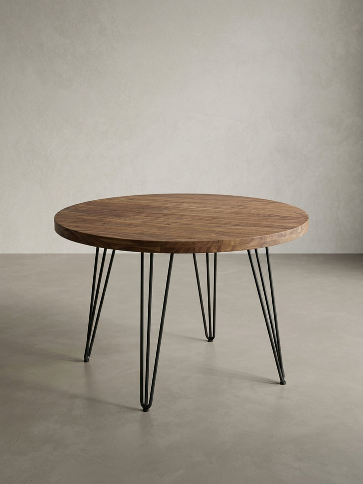Alternative Perspektive des modernen Esstisches in Braun und Schwarz. Die elegante Proportion der 120 cm runden Tischplatte zu den feinen Hairpin-Beinen aus Metall wird hier deutlich._