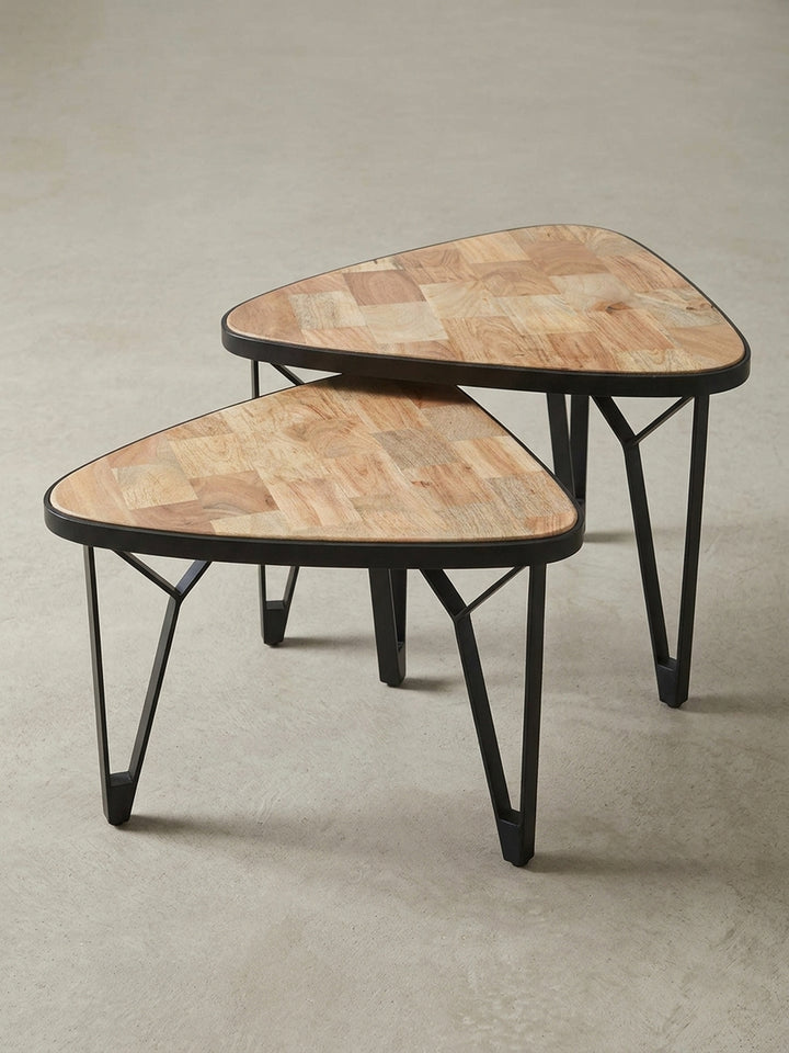 Schräge 3/4-Ansicht des zweiteiligen Satztisches, die die filigranen, schwarzen Metallbeine und die parkettartige Holzplatte des 60cm Tisches zeigt._