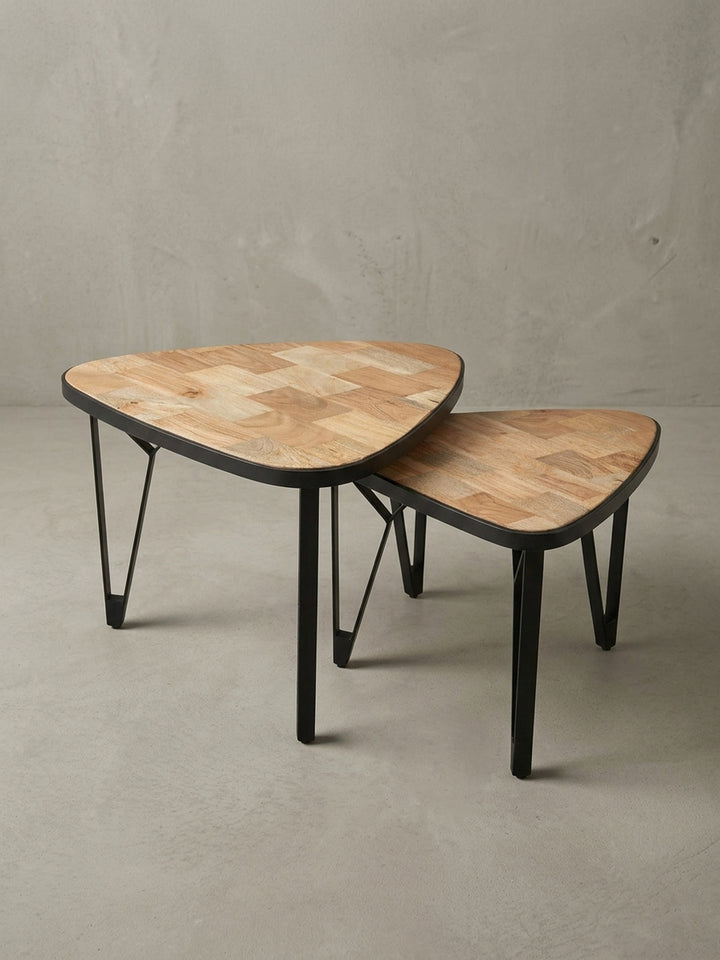 Detailansicht der Tischbeinkonstruktion des kleineren Tisches, die die stabile Befestigung der pulverbeschichteten Eisenbeine unter der Massivholzplatte zeigt._