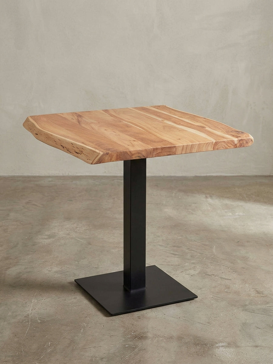 Alternative Perspektive des Baumkanten-Tisches, die das Zusammenspiel von natürlicher Form und geradlinigem, industriellem Design des Metallgestells verdeutlicht._