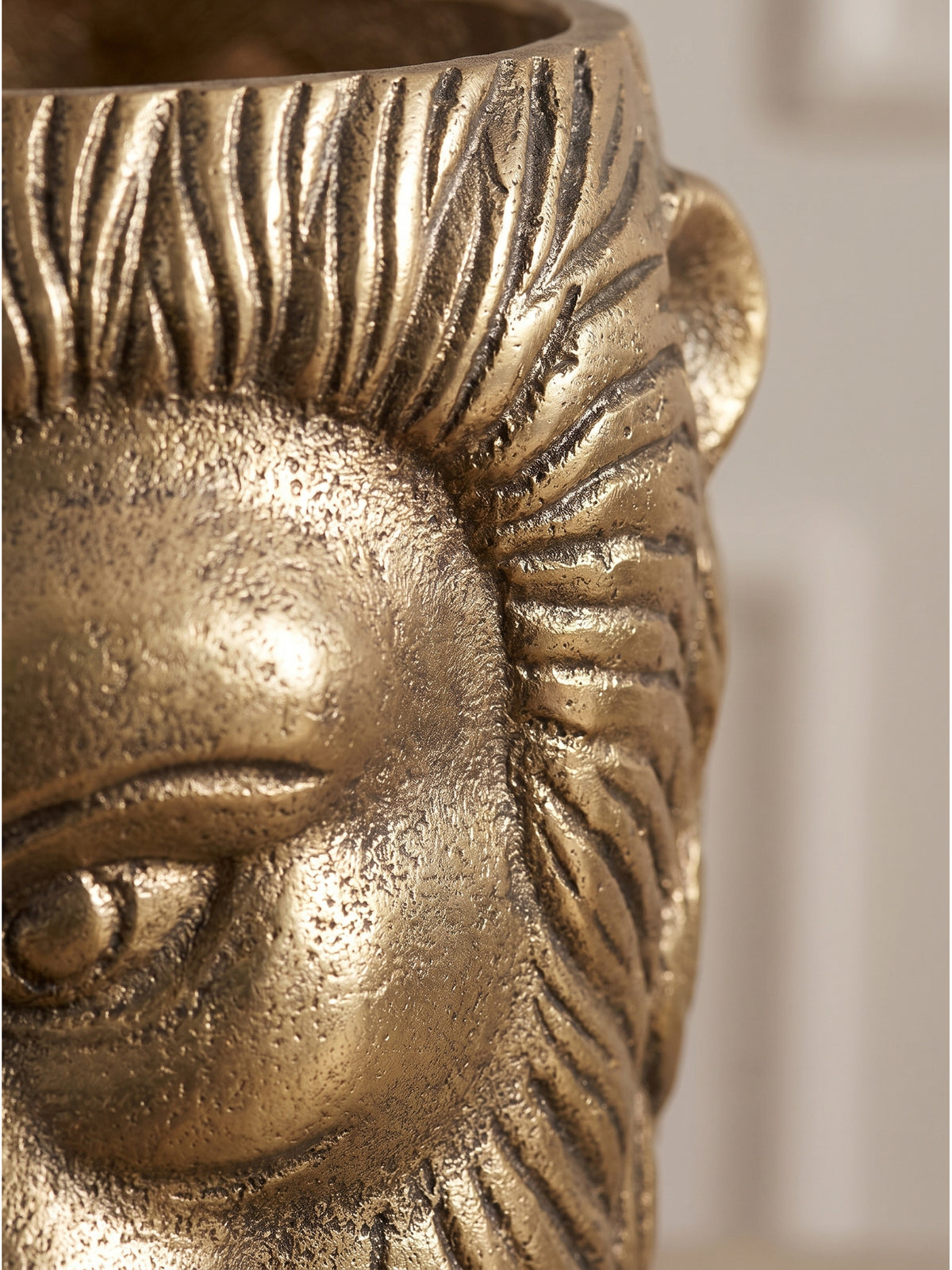 Nahaufnahme der handgefertigten Struktur: Massives Aluminium mit goldener Lackierung zeigt detailliert die Mähne der majestätischen Löwen-Vase.