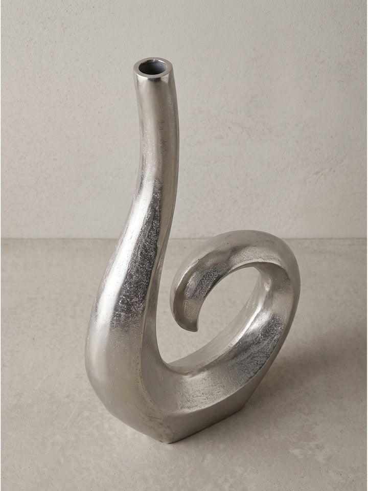 Skulpturale Blumenvase aus Alu in Silber im Halbprofil zeigt das markante Design vor neutralem Hintergrund._
