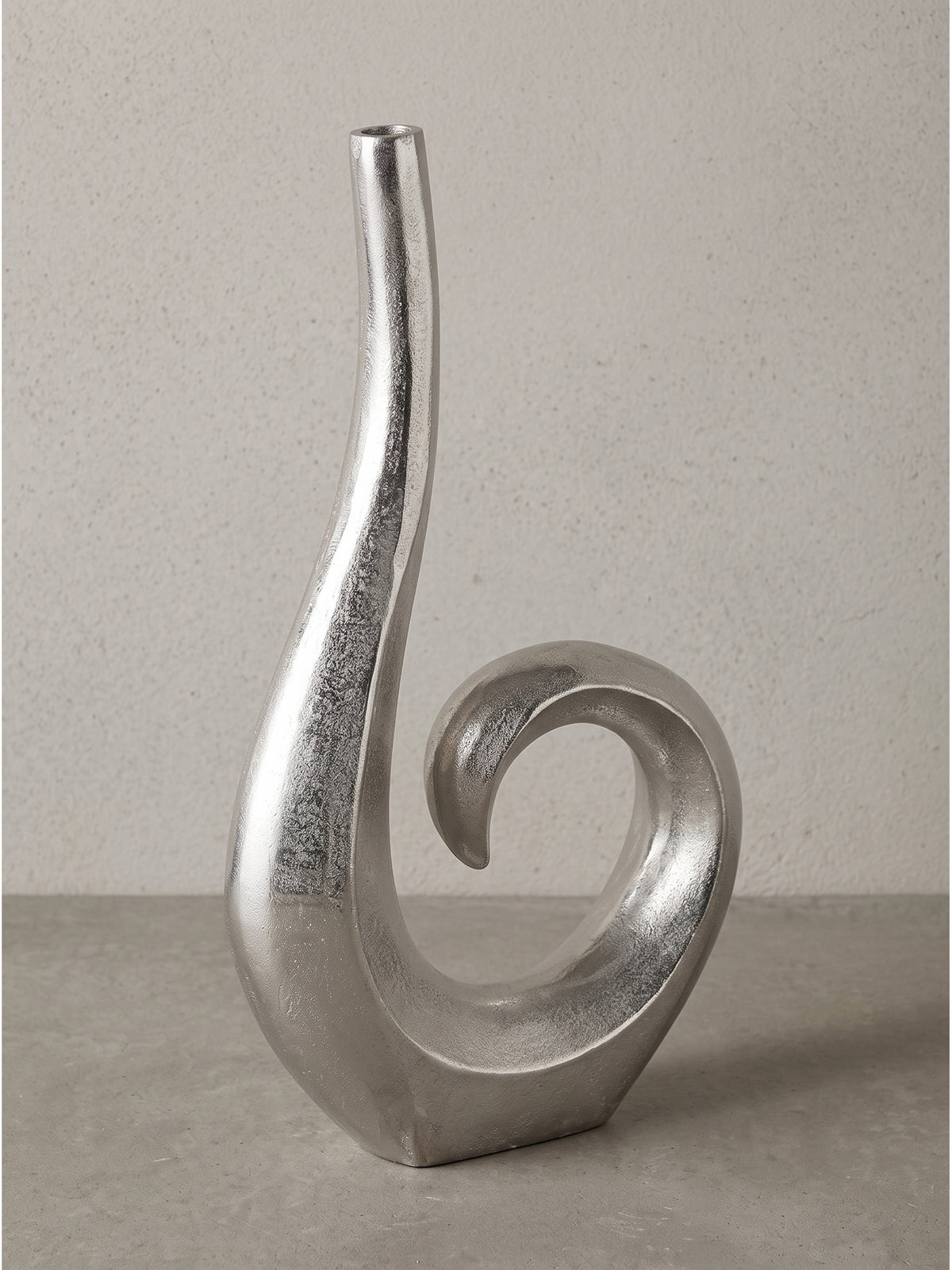 Detailaufnahme des Standfußes der extravaganten modernen Blumenvase aus Alu in Silber vor weißem Hintergrund.