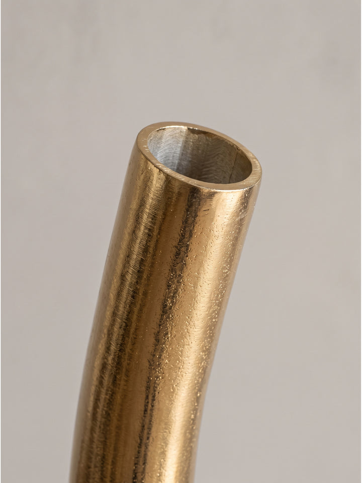 Detailansicht der fließenden organischen Spiralenform der goldenen Standvase aus Metall ohne zusätzliche Dekoration._