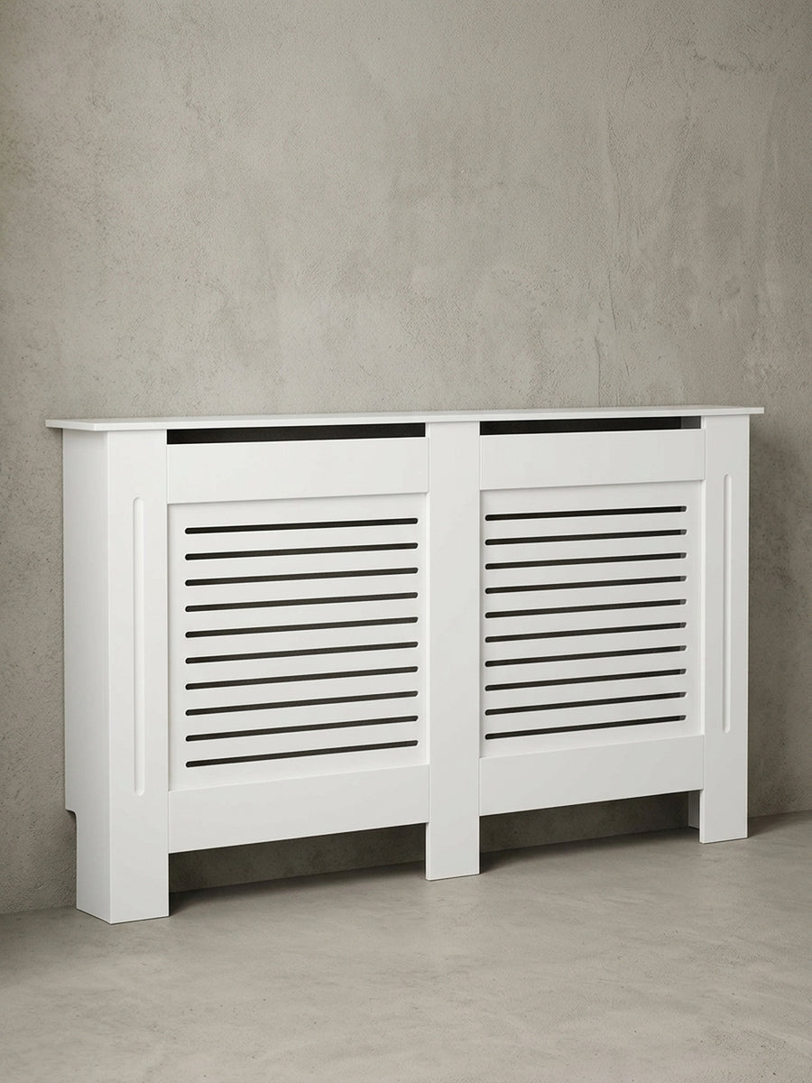 Frontansicht der 152x83x19 cm großen Heizkörperverkleidung in Weiß matt. Schlichtes architektonisches Design mit horizontalen Schlitzen zur optimalen und unsichtbaren Wärmezirkulation._