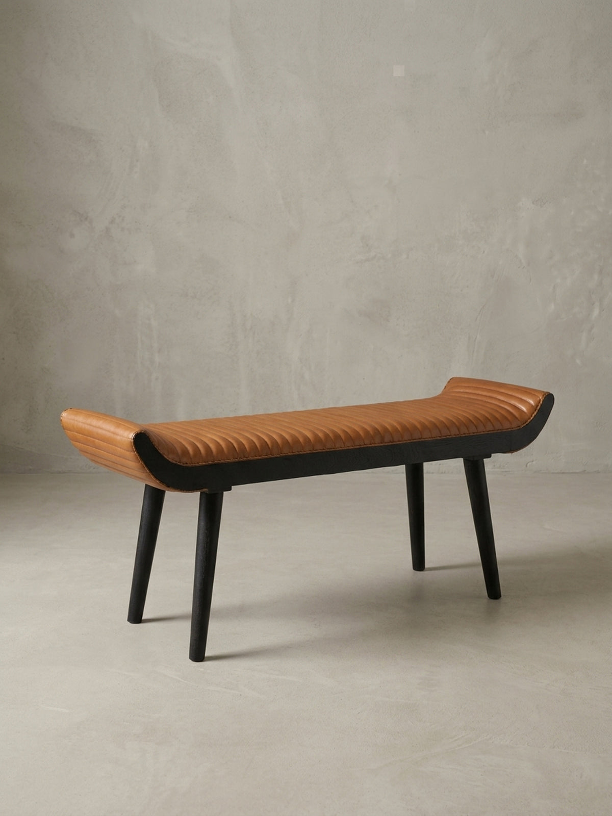Seitenansicht der Polsterbank, die das schlanke Profil und die Höhe von 51 cm zeigt. Die konisch zulaufenden Beine aus Mangoholz unterstreichen das Design._