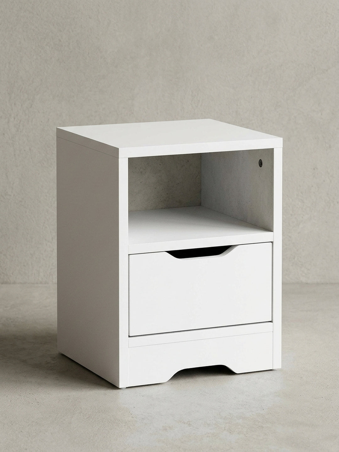 Frontansicht der schlichten weißen Nachtkommode mit kompakten Maßen von 31x43x31cm. Das Design umfasst ein praktisches offenes Fach und eine geräumige Schublade mit Griffmulde._