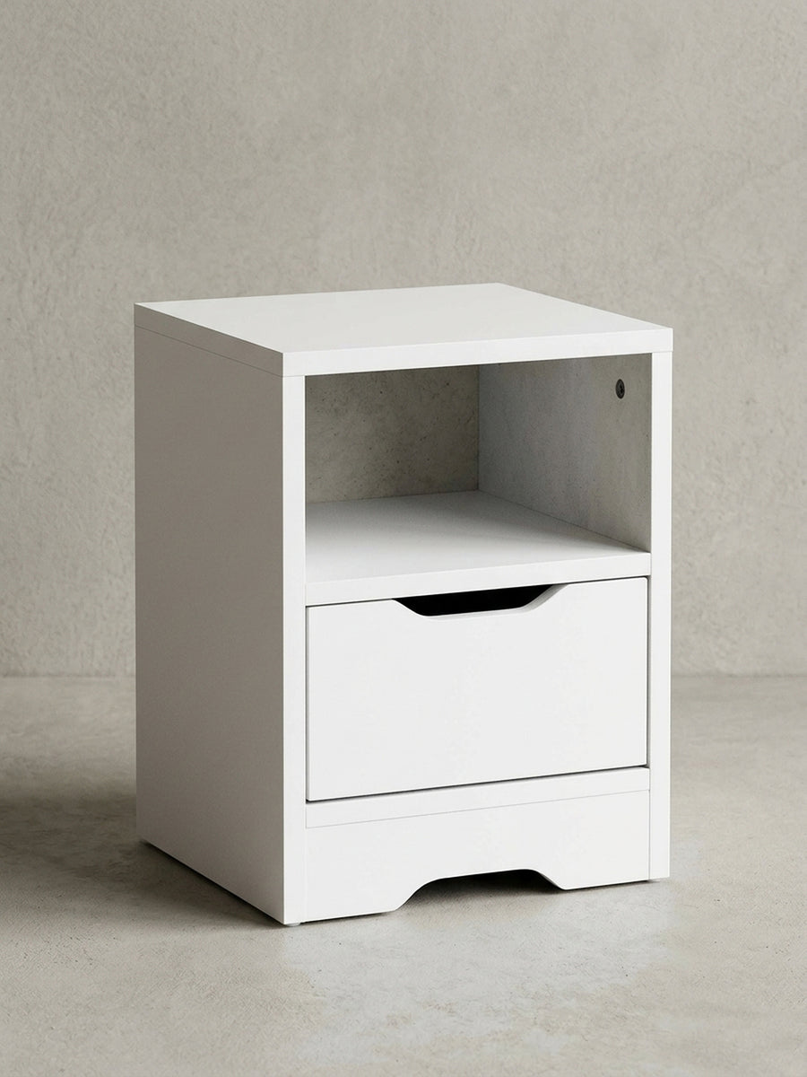 Frontansicht der schlichten weißen Nachtkommode mit kompakten Maßen von 31x43x31cm. Das Design umfasst ein praktisches offenes Fach und eine geräumige Schublade mit Griffmulde._
