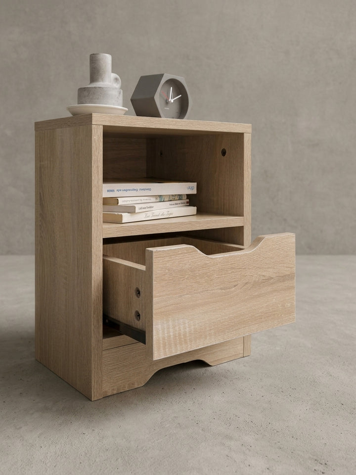 Fokus auf die grifflose Schublade der modernen Nachtkonsole. Der ergonomische Ausschnitt an der Frontseite ermöglicht ein leichtes Öffnen und schließt optisch bündig mit dem hellen Korpus ab_