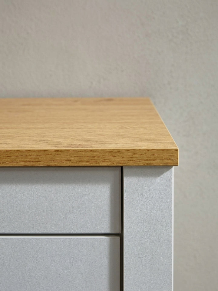 Gesamtansicht der weiß-eichefarbenen Kommode als vielseitiges Stauraummöbel für Wohnzimmer, Schlafzimmer oder Esszimmer._