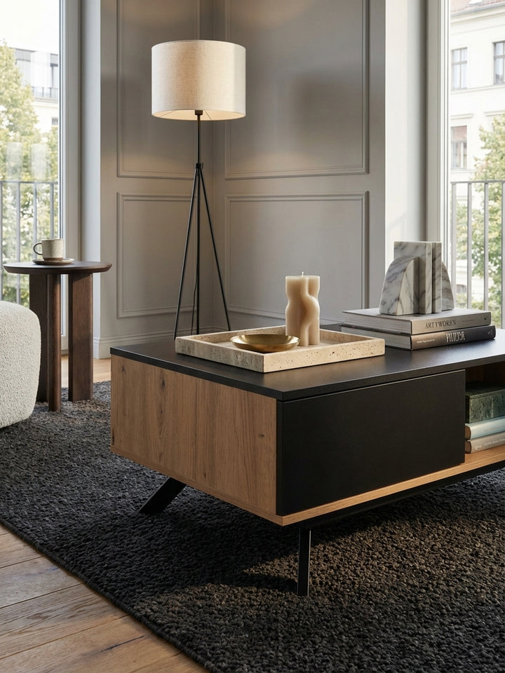 Nahaufnahme der Materialtextur des Wohnzimmertisches, zeigt die feine Maserung des Eiche-Dekors und die matte Oberfläche der schwarzen Schublade aus MDF._