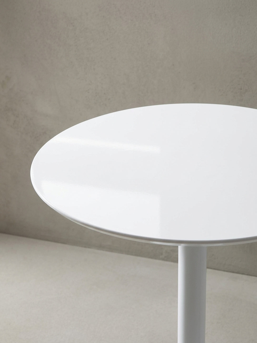 Eine alternative Perspektive auf den modernen Frühstückstisch, die die glänzende Oberfläche und die perfekte runde Form der 75 cm großen Tischplatte betont._