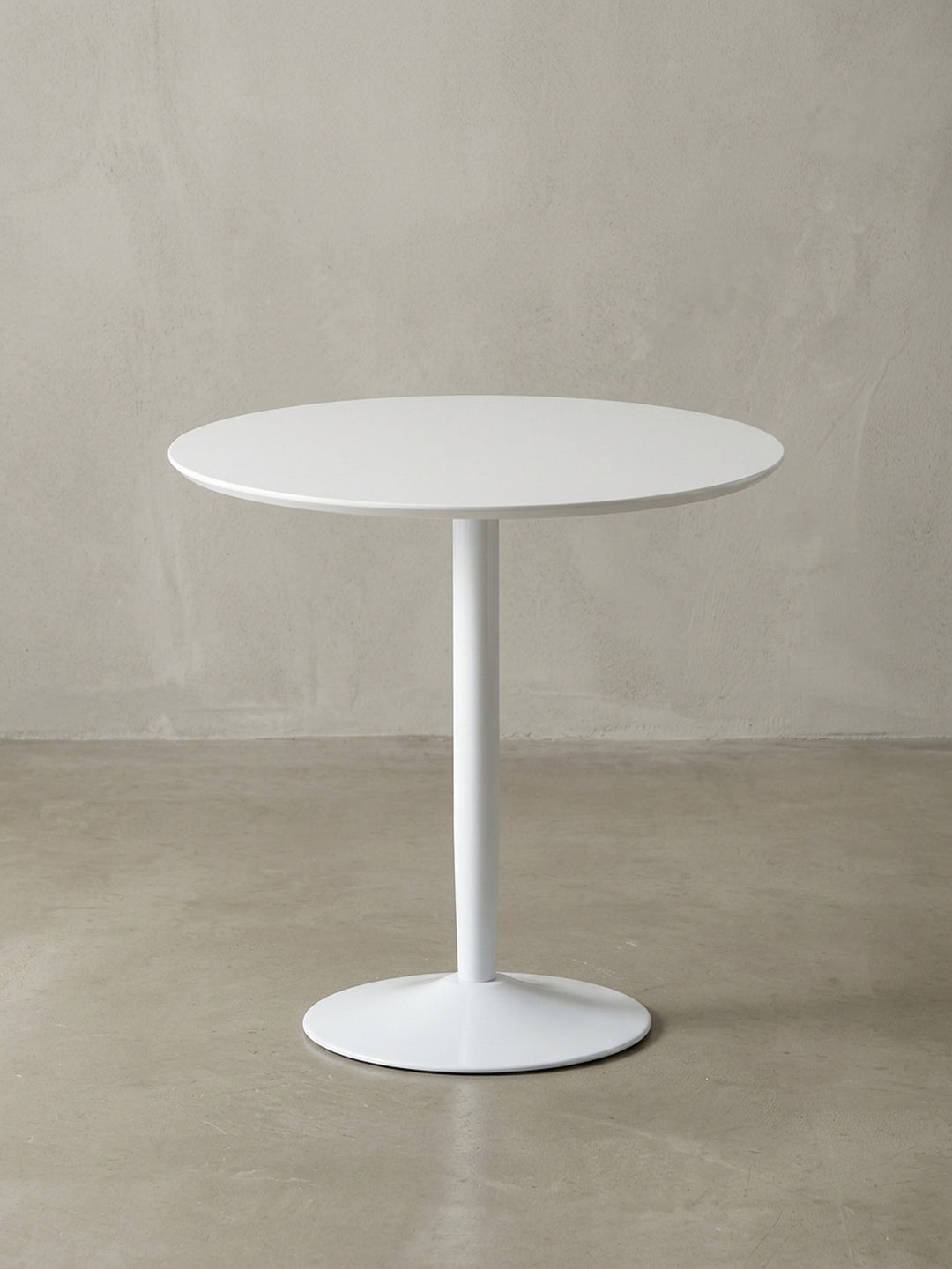 Der runde Küchentisch für 2 Personen aus einer eleganten 3/4-Perspektive, die das zeitlose Design des weißen Tisches mit seinem stabilen Standfuß zeigt._