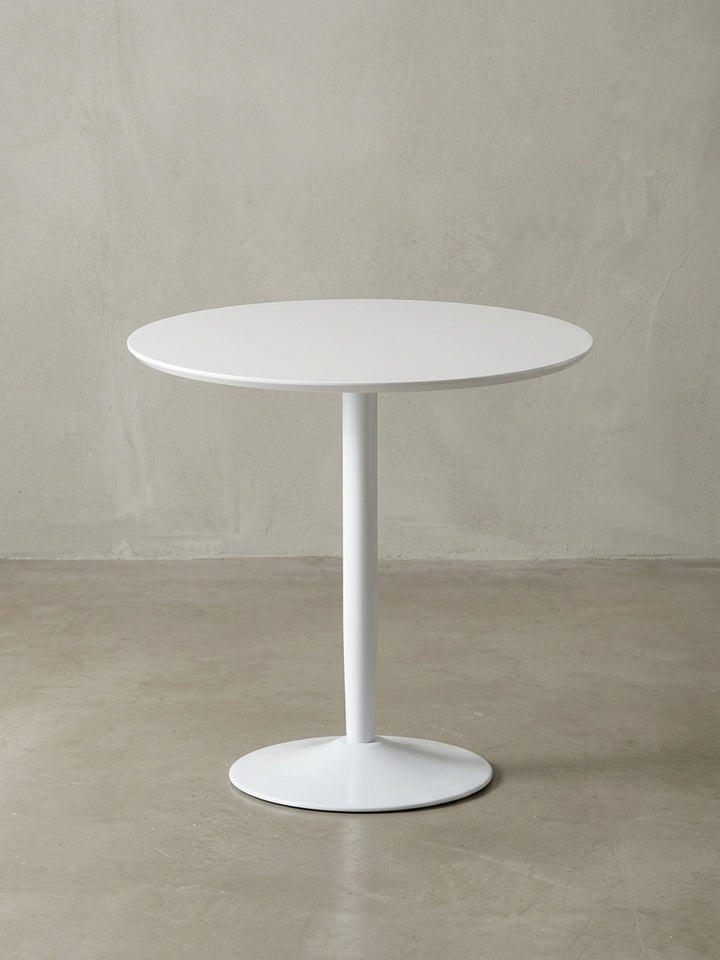 Der runde Küchentisch für 2 Personen aus einer eleganten 3/4-Perspektive, die das zeitlose Design des weißen Tisches mit seinem stabilen Standfuß zeigt._