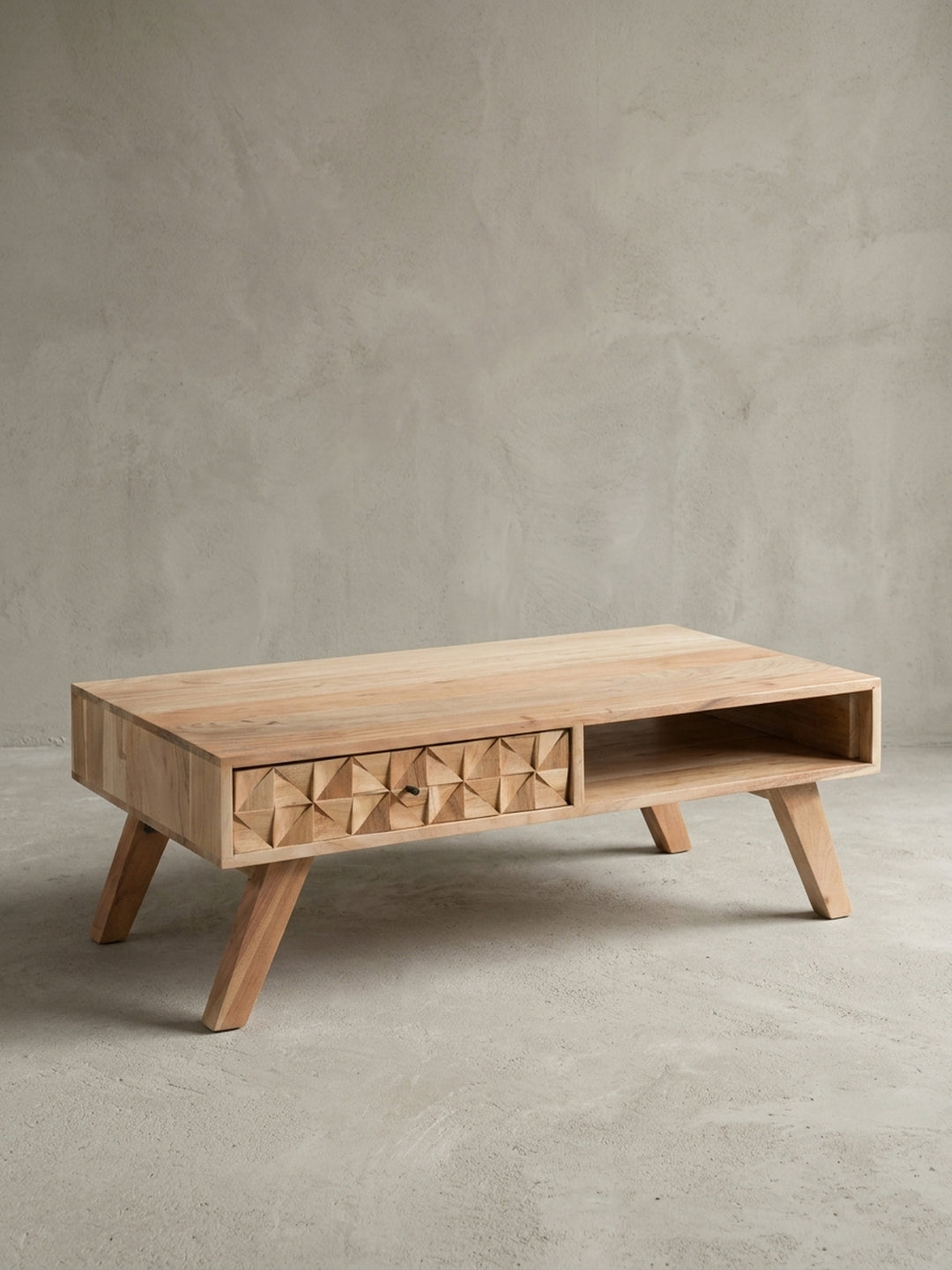 Vorderansicht des Couchtisches REWA aus massivem Akazienholz. Der 95cm breite Sofatisch kombiniert ein offenes Fach mit einer markanten, geometrisch gefrästen Schublade auf Beinen._