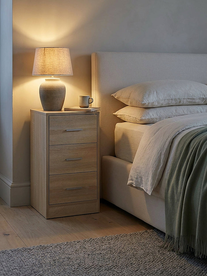 Schlafzimmer-Detail mit einer Steinzeug-Tischlampe und einem Leinen-Notizbuch auf der obersten Ablage des modernen Nachtkästchens._