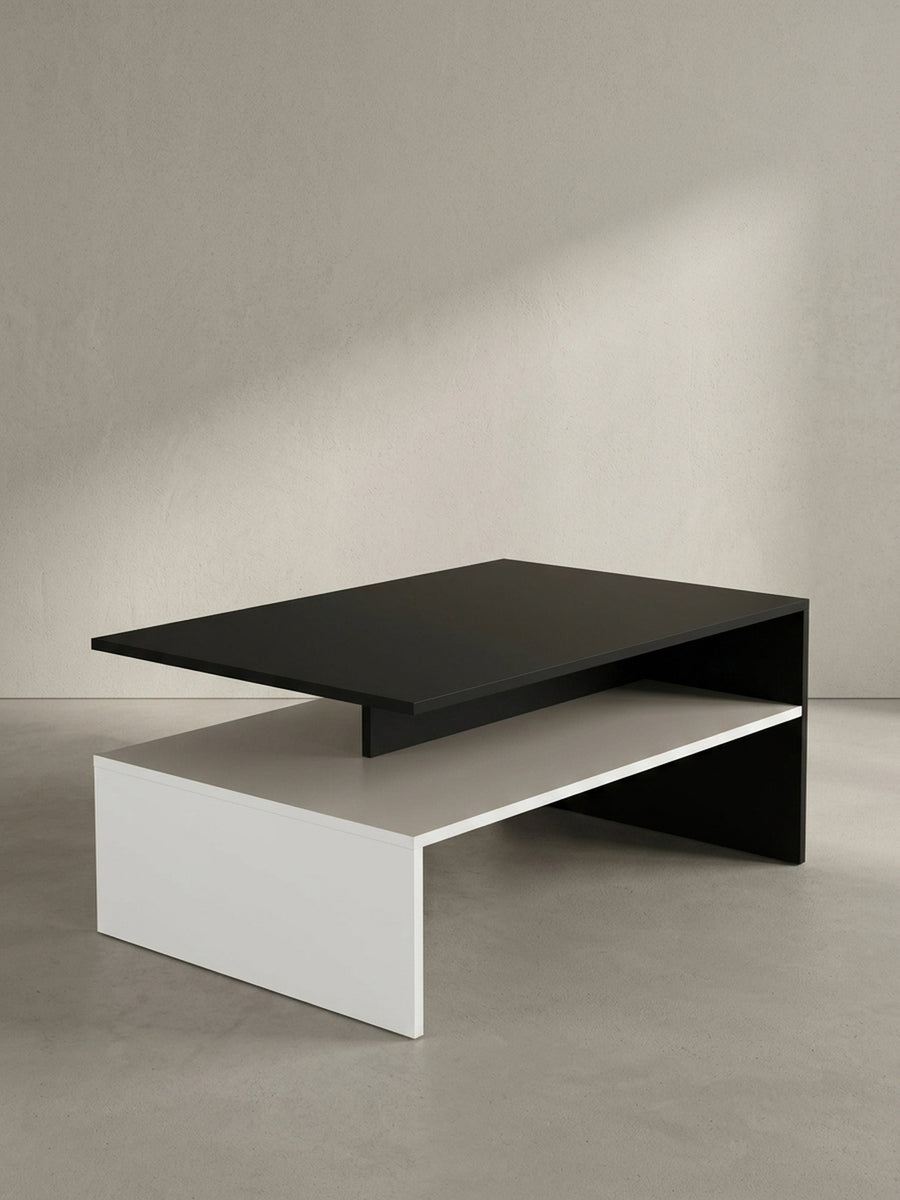 Viereckiger Couchtisch 90x60x43 cm in asymmetrischem Design mit schwarzer Tischplatte und weißem Sockel freigestellt vor weißem Hintergrund_