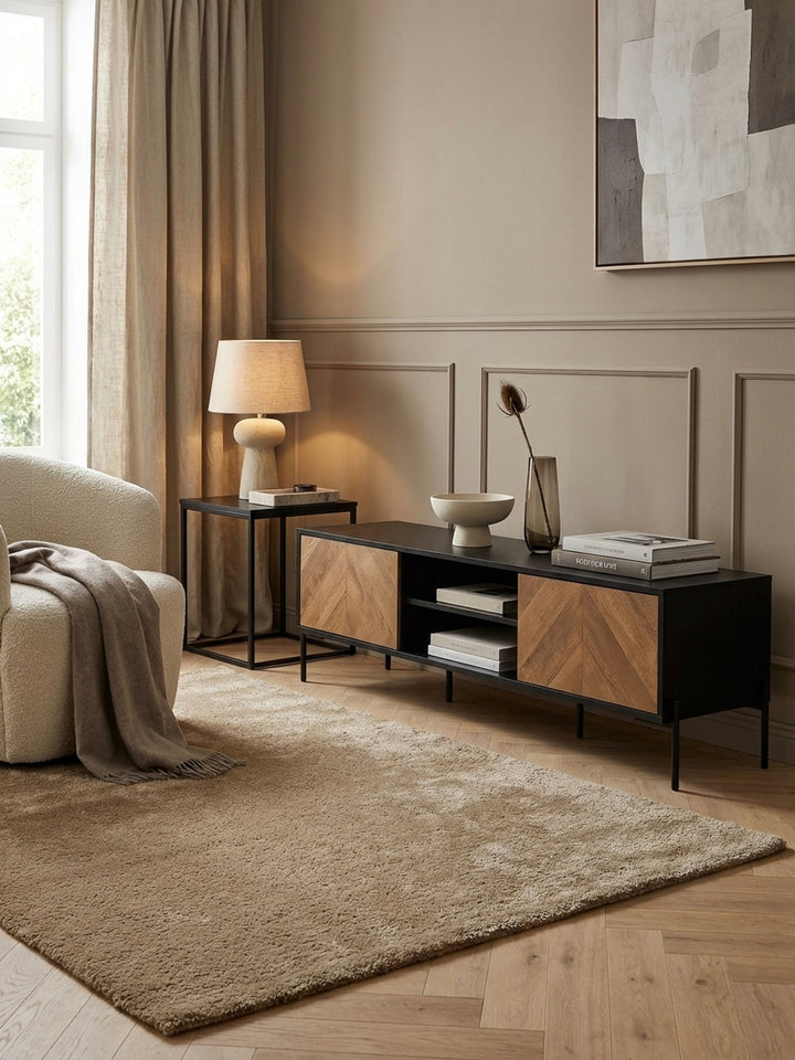 Modernes Lowboard 163 cm breit aus schwarzem Holz und Eiche-Dekor als stilvoller TV-Schrank in einem minimalistisch eingerichteten Wohnzimmer mit Wollteppich._