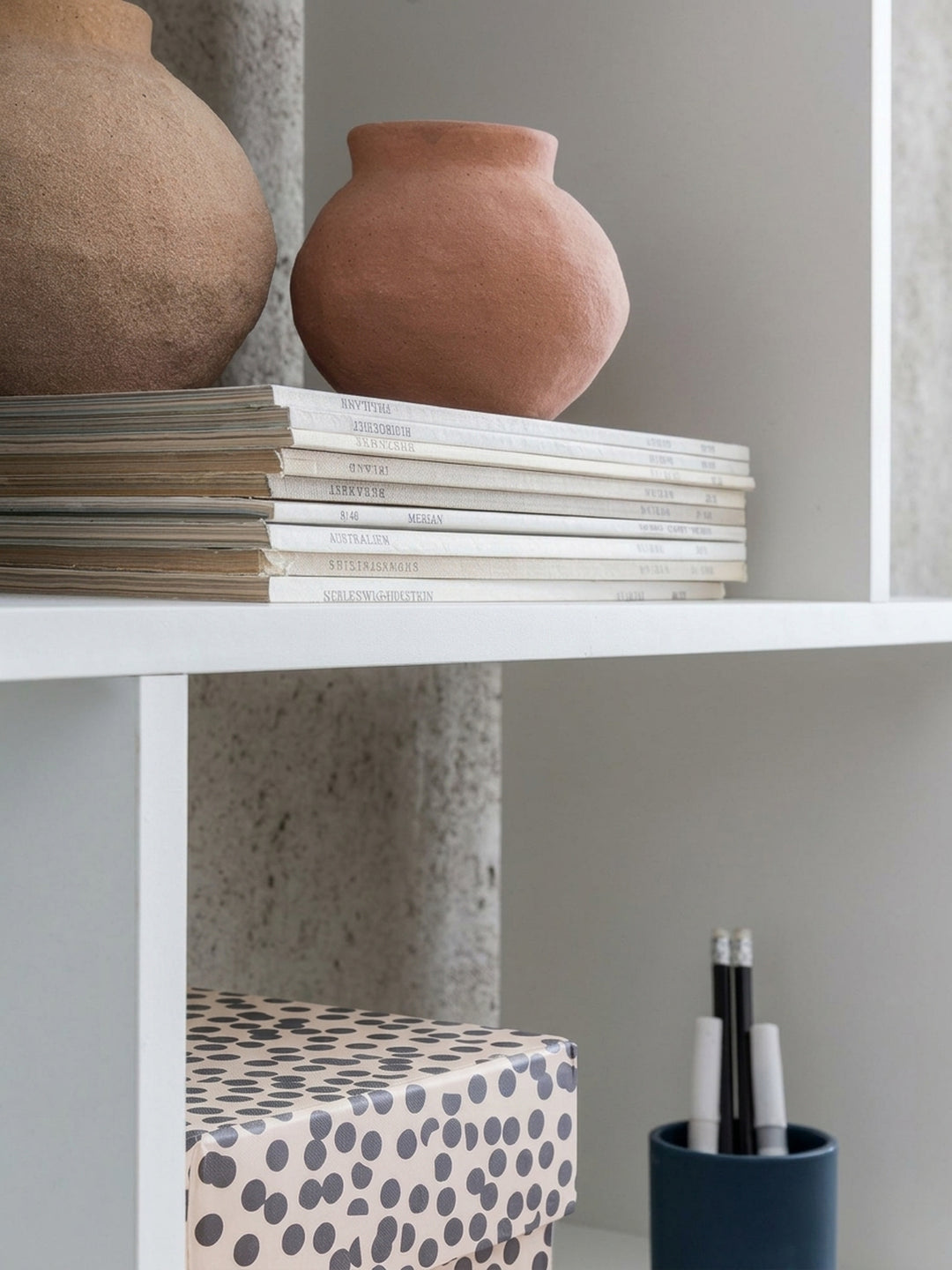 Nahaufnahme der stabilen Fachböden des weißen Design-Regals. Die 1,5 cm starke Spanplatte des offenen Bücherregals garantiert hohe Traglast für Bücher im Home-Office oder Wohnzimmer._
