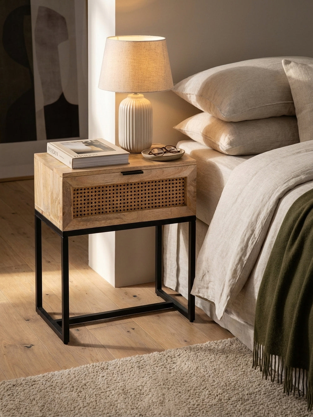 Stilvoller Nachttisch mit einer Keramiklampe und einem aufgeschlagenen Buch, schafft eine gemütliche Leseatmosphäre im Schlafzimmer._