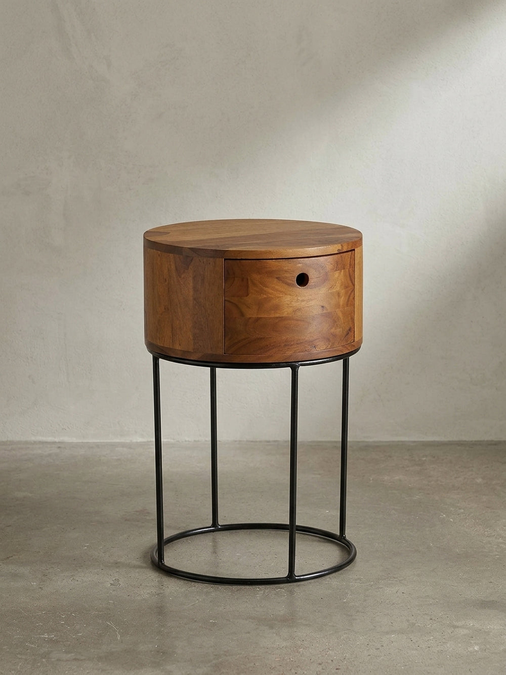 Freigestellter runder Nachttisch 40x60 cm aus massivem Sheeshamholz mit einer Schublade und schwarzem Metallgestell, Frontalansicht._