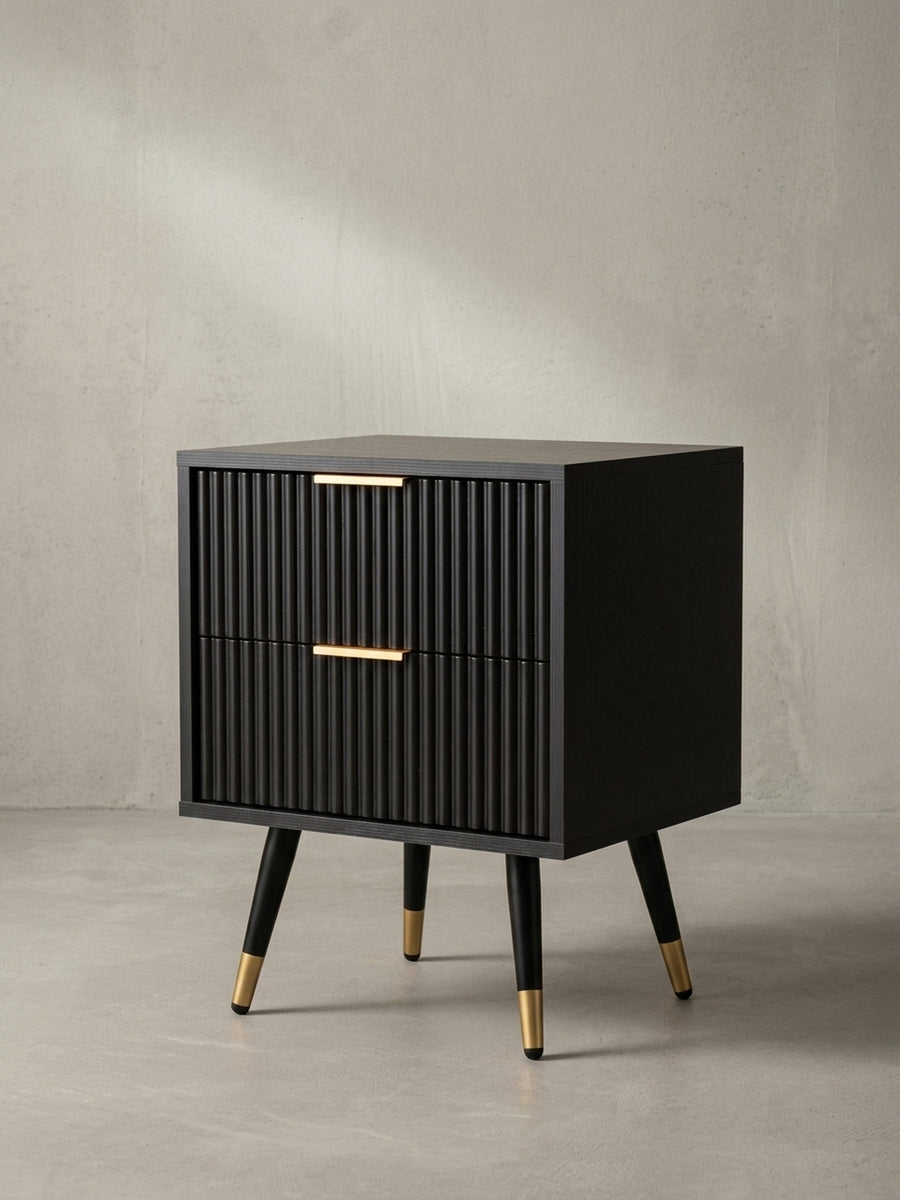 Seitenansicht des schmalen Nachttisches, die seine schlanke Silhouette und die eleganten, konischen Beine mit Goldkappen hervorhebt._