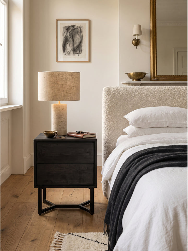 Elegantes Schlafzimmer-Set mit einem Nachttisch aus schwarzem Akazienholz und einem hellen Polsterbett harmonisch kombiniert._