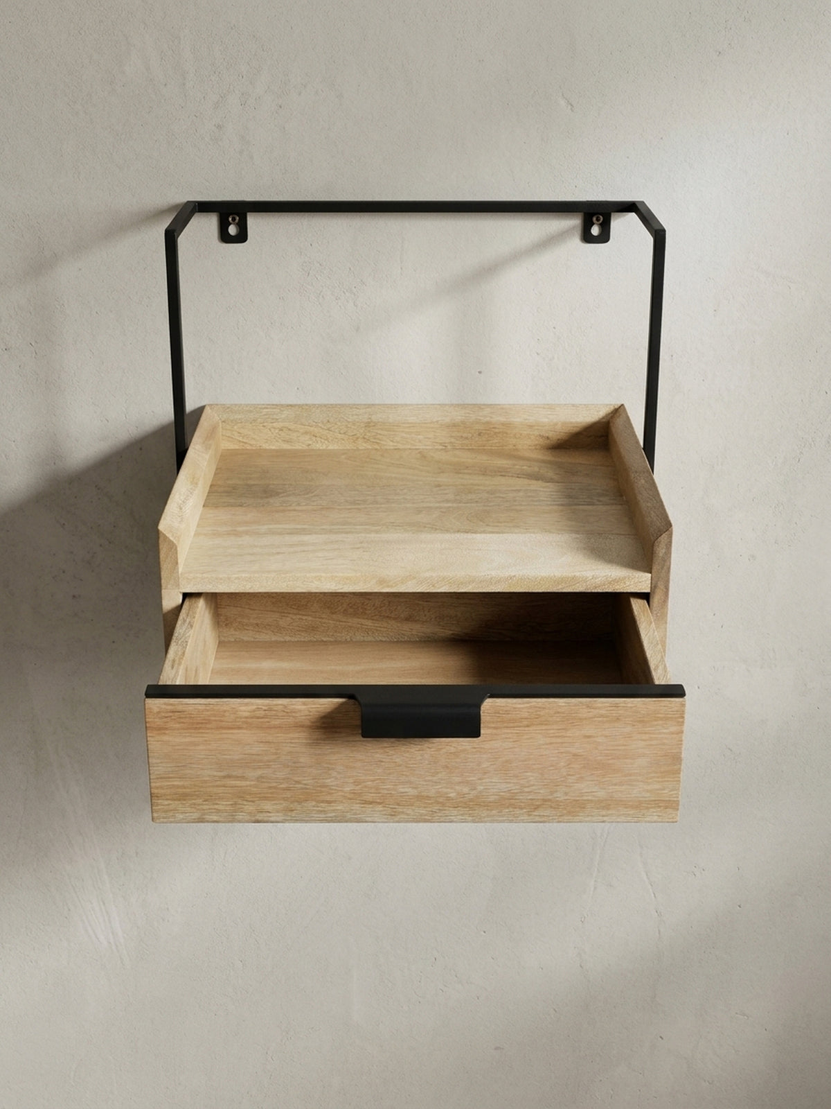 Perspektivische Ansicht des Wandboards mit Schublade, die das Zusammenspiel von warmer Holzoberfläche und kühlem, schwarzem Metallgriff betont._