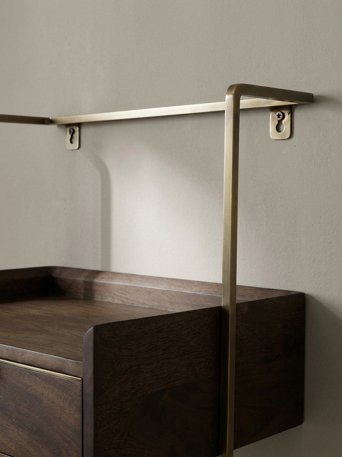 Eine weitere Perspektive auf den Designer-Nachttisch, die den eleganten Übergang vom dunklen Holz zum warmen Messing-Ton des Rahmens betont._