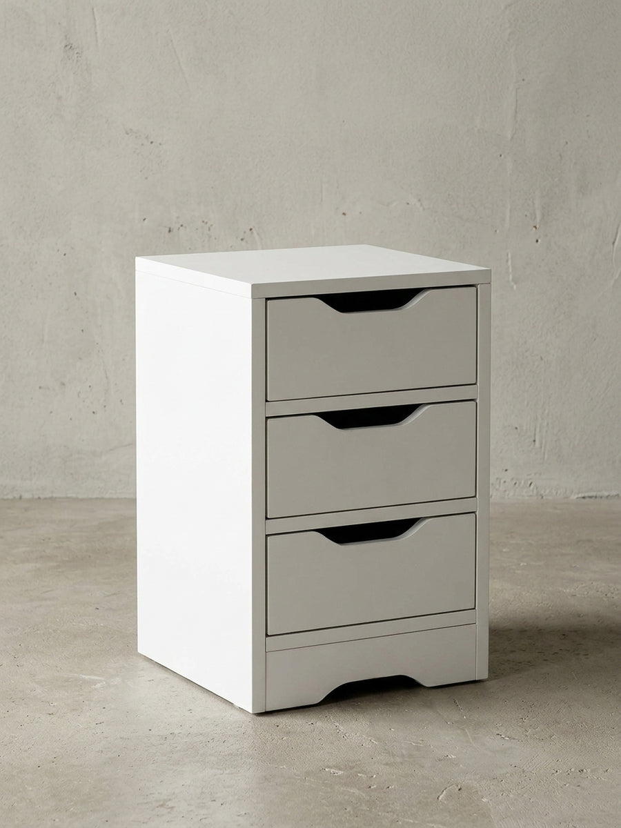 Frontale Ansicht der weißen Nachtkonsole mit drei geräumigen Schubladen. Die praktischen Griffmulden unterstreichen das minimalistische, grifflose Design des Möbelstücks._