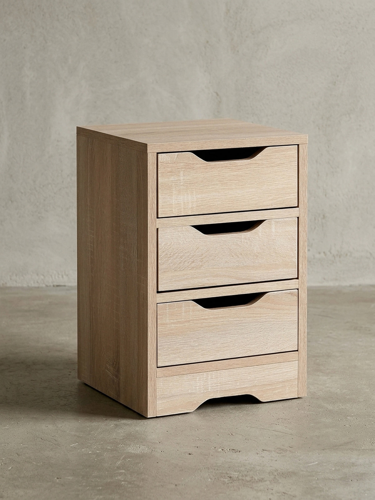 Schlichter Nachttisch aus Holzwerkstoff in Frontalansicht vor weißem Hintergrund. Die drei übereinanderliegenden Schubladen bieten viel Stauraum bei kompakten Maßen von 31x49 cm.
