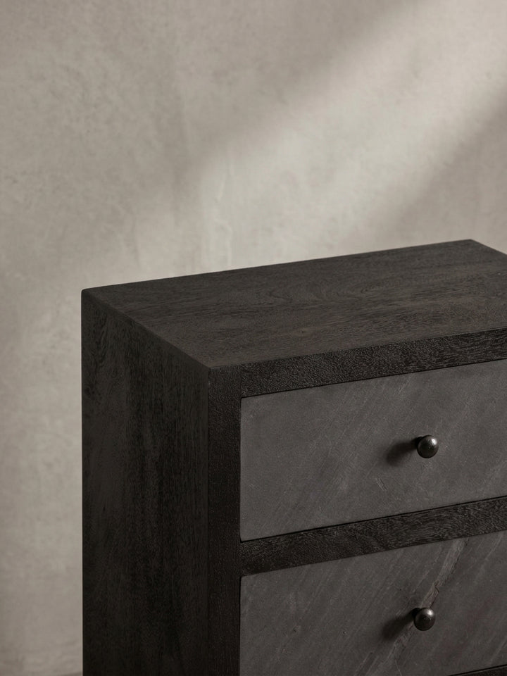 Design-Nachttisch aus einer alternativen Perspektive, die die mattschwarzen, runden Griffe und die präzise Verarbeitung der Schubladen hervorhebt._
