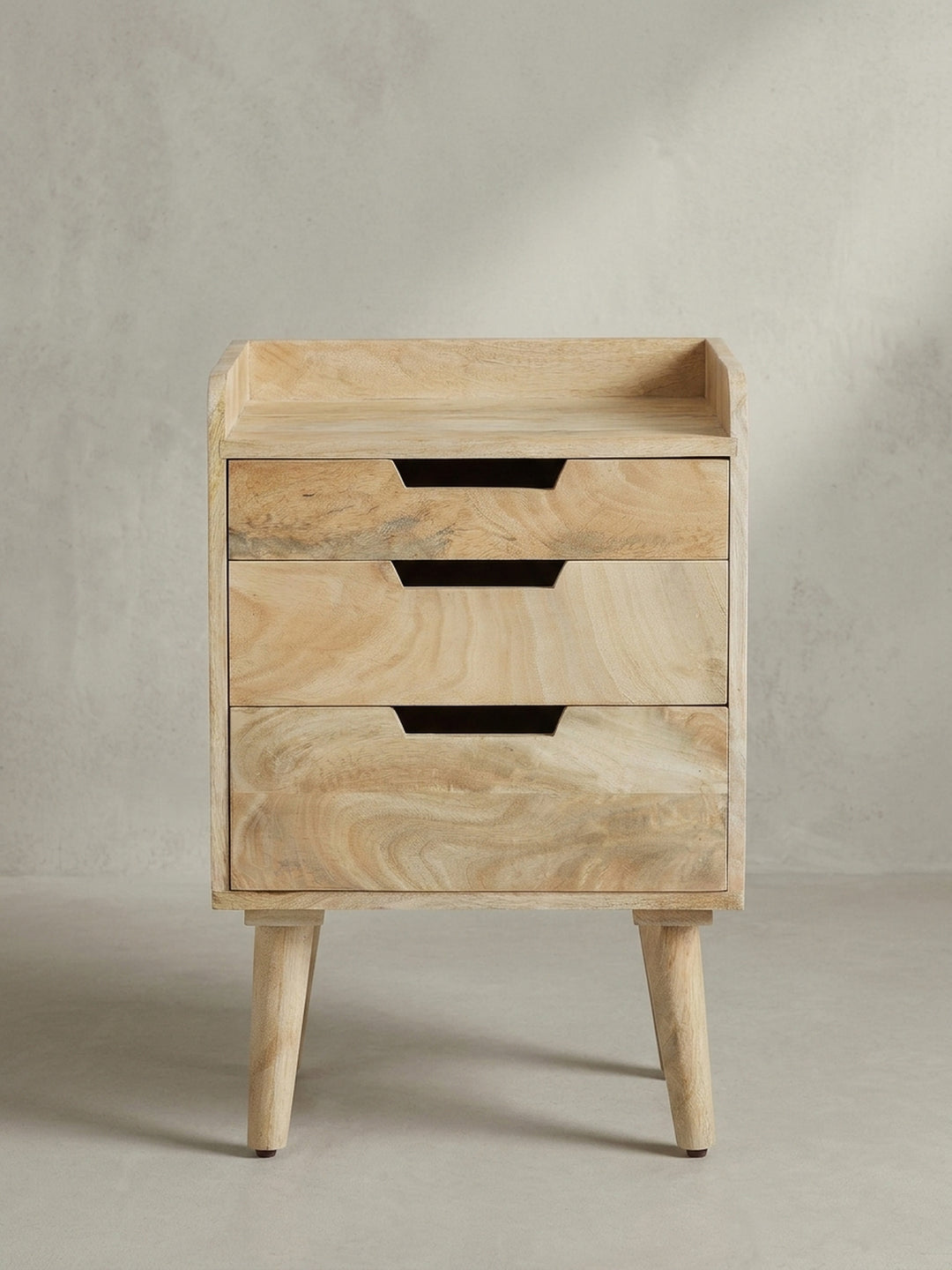 Seitenansicht des 63 cm hohen Nachtschranks aus Massivholz, ideal für hohe Boxspringbetten, das skandinavische Design der Beine ist sichtbar._