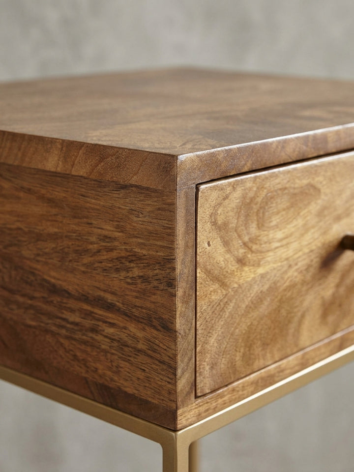 Gesamtüberblick des Nachttisches mit Schublade. Die Kombination aus warmem Mangoholz und kühlem, lackiertem Eisen schafft einen spannenden Materialkontrast._