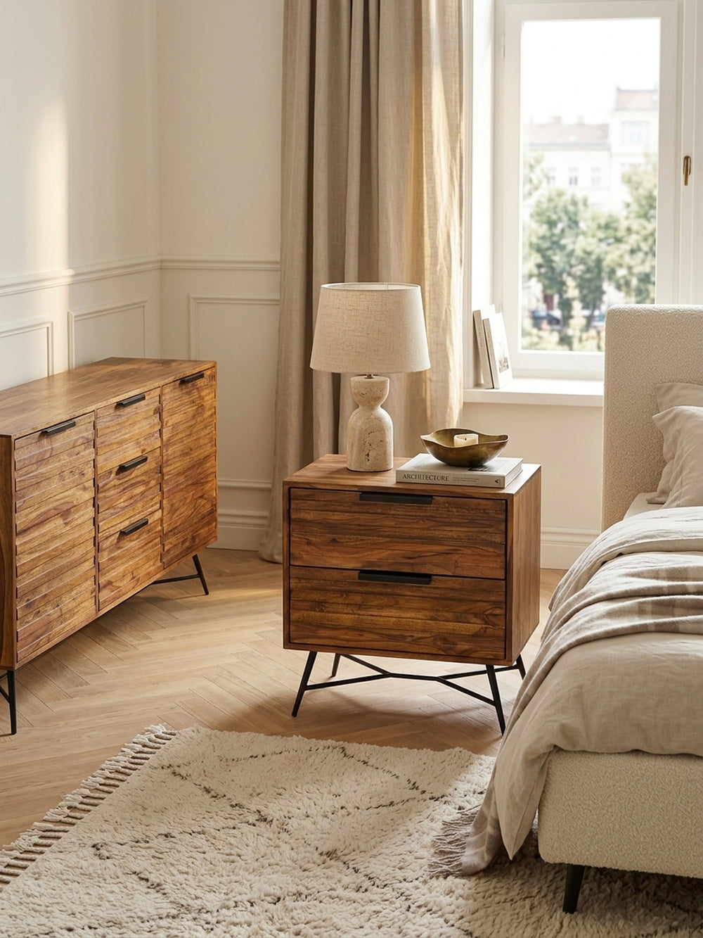 Draufsicht auf den 60x40 cm breiten Sheesham Holz Nachttisch mit schwarzen Metallgriffen. Harmonische Schlafzimmer Einrichtung mit cremefarbenem Teppich und Deko._