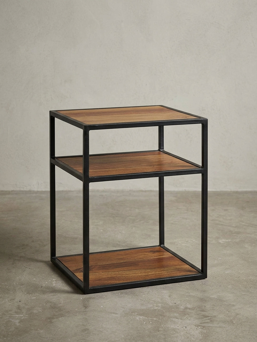 Frontansicht des Nachttischs im Industrial Design, 50 cm hoch, mit drei Ablagen aus Sheesham-Holz und einem stabilen, offenen Gestell aus schwarzem Metall._