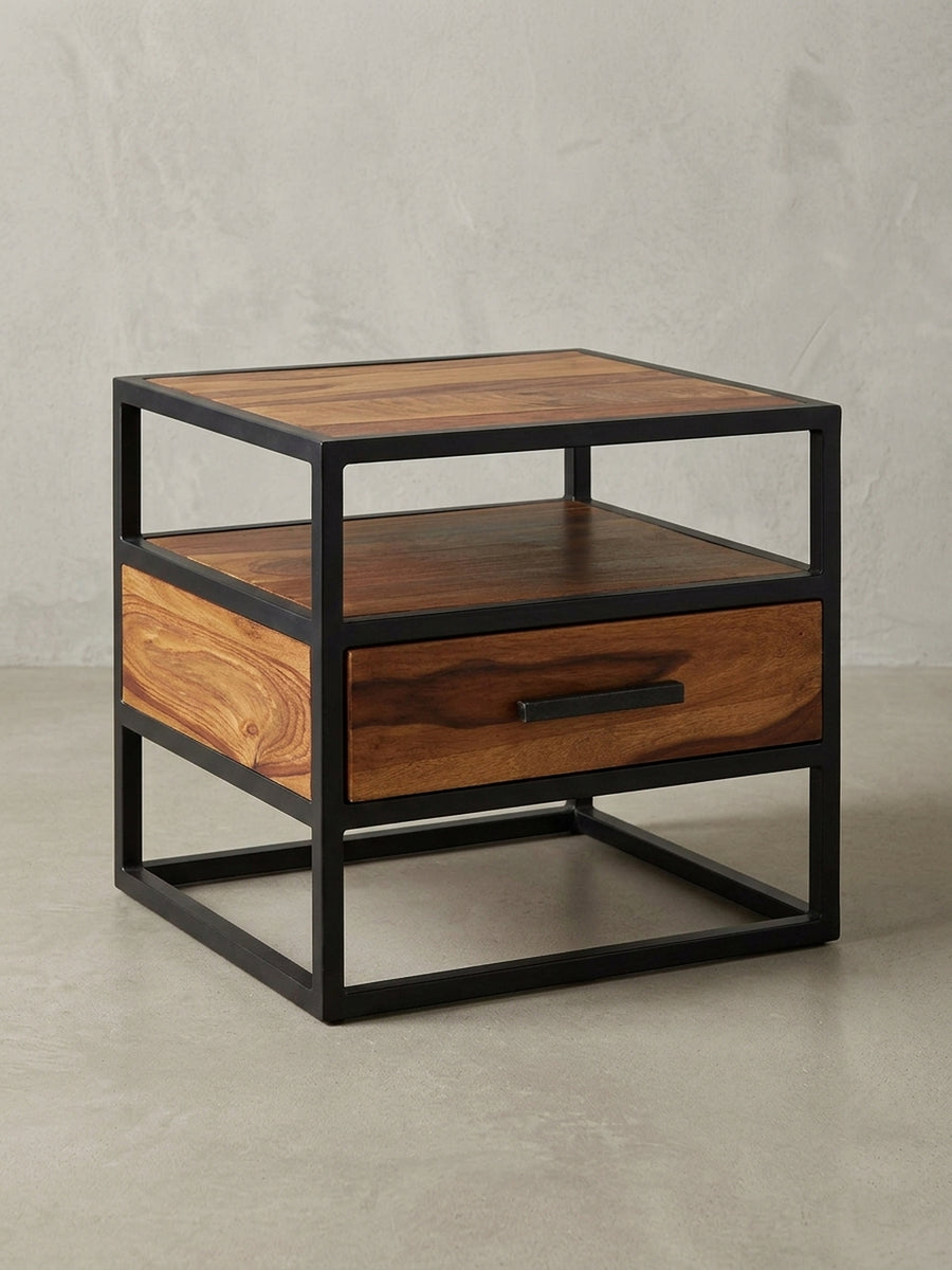 Nachttisch im Industrial Design auf weißem Hintergrund. Die Kombination aus massivem Rosenholz und dem schwarzen Metallgestell prägt die geradlinige Silhouette des 45 cm hohen Nachtschranks._