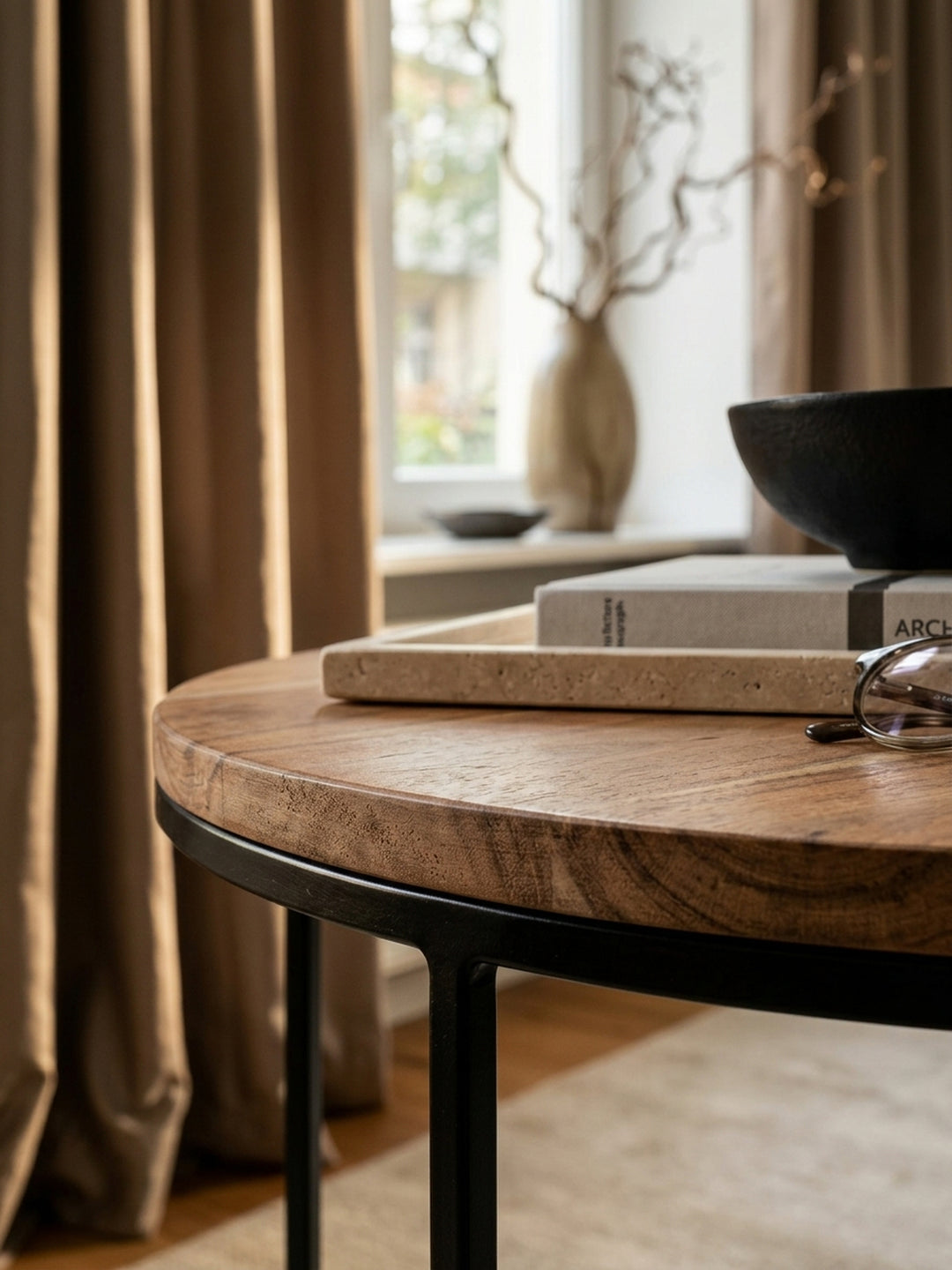 Nahaufnahme der edlen Akazienholzplatte. Die markante, warme Maserung des Massivholzes und die feine 1,5 cm starke Kante des runden Design Couchtisches sind detailliert erkennbar._