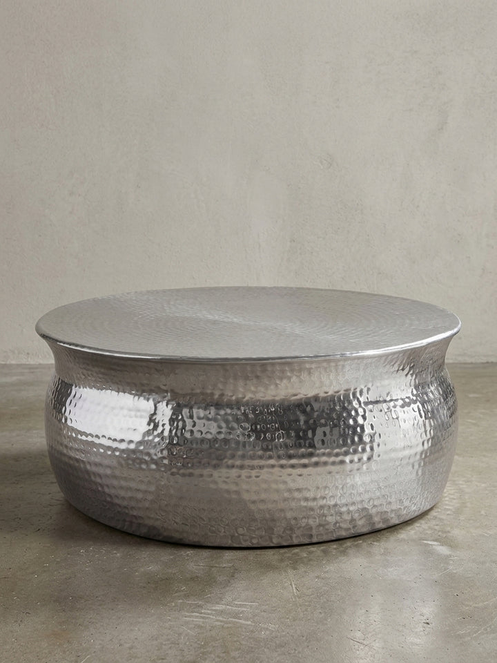 Silberner Couchtisch aus Metall in bauchiger Form freigestellt vor weißem Hintergrund. Der 31cm flache Loungetisch besticht durch sein orientalisches Struktur-Design._