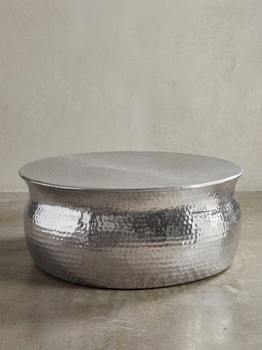 Silberner Couchtisch aus Metall in bauchiger Form freigestellt vor weißem Hintergrund. Der 31cm flache Loungetisch besticht durch sein orientalisches Struktur-Design._