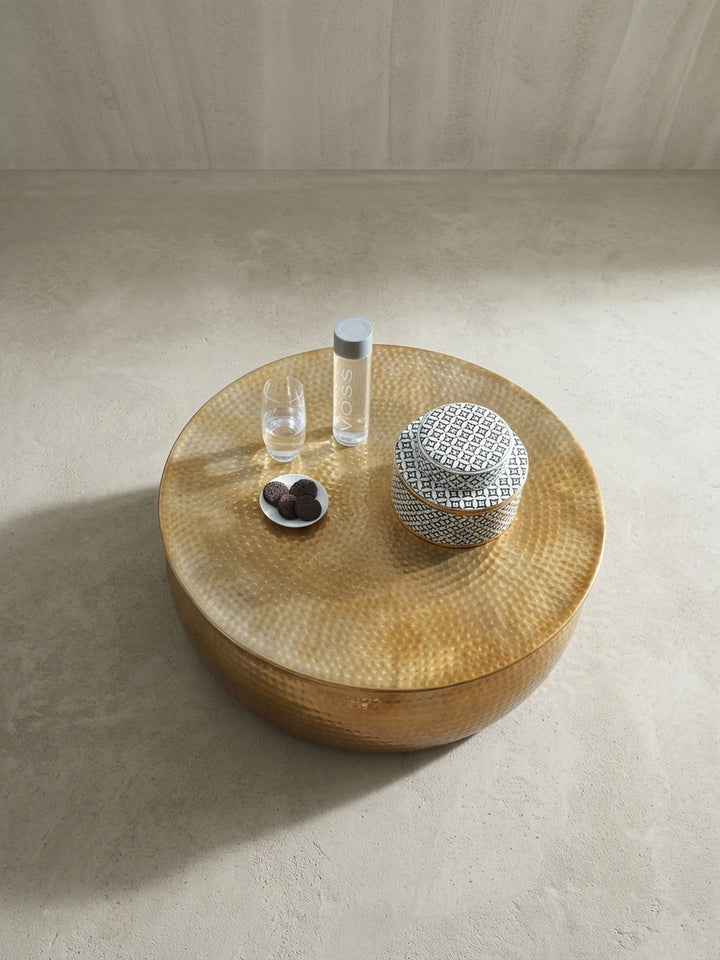 Alternative Perspektive auf den 75 cm breiten, runden Stubentisch in Gold. Das glänzende Aluminium mit Hammerschlag-Muster bringt einen Hauch von Glamour ins moderne Zuhause._