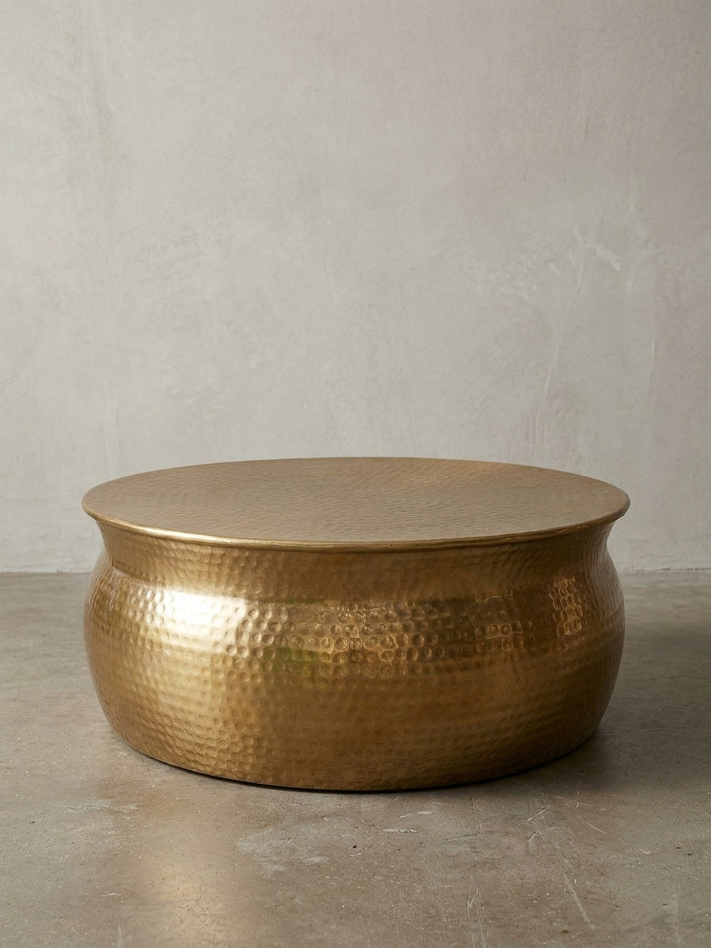 Runder Couchtisch aus Aluminium in Gold mit Hammerschlag-Optik, frontal auf weißem Hintergrund. Der 75x75x31 cm große Stubentisch überzeugt durch sein orientalisches Design._