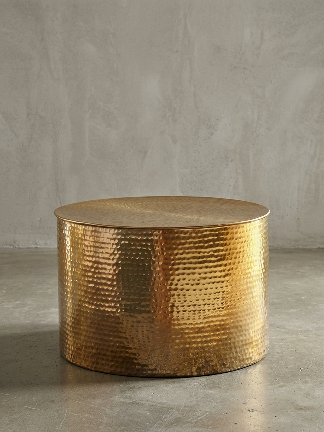 Runder Couchtisch aus Aluminium in strahlendem Gold freigestellt vor weißem Hintergrund. Die kompakte Zylinderform des 40 cm hohen Wohnzimmertisches wirkt modern und massiv._